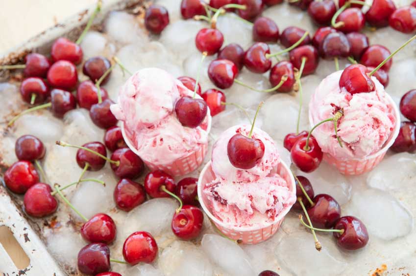 Creamy ice cream with fresh cherries on cold ice cubes